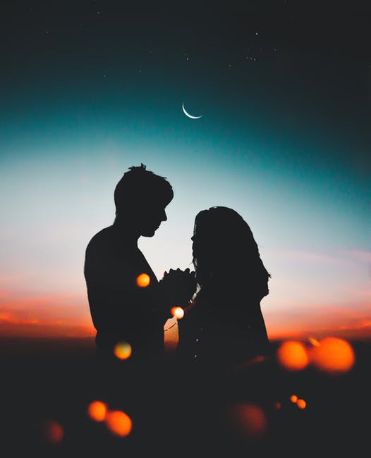 couple in love with moon in background